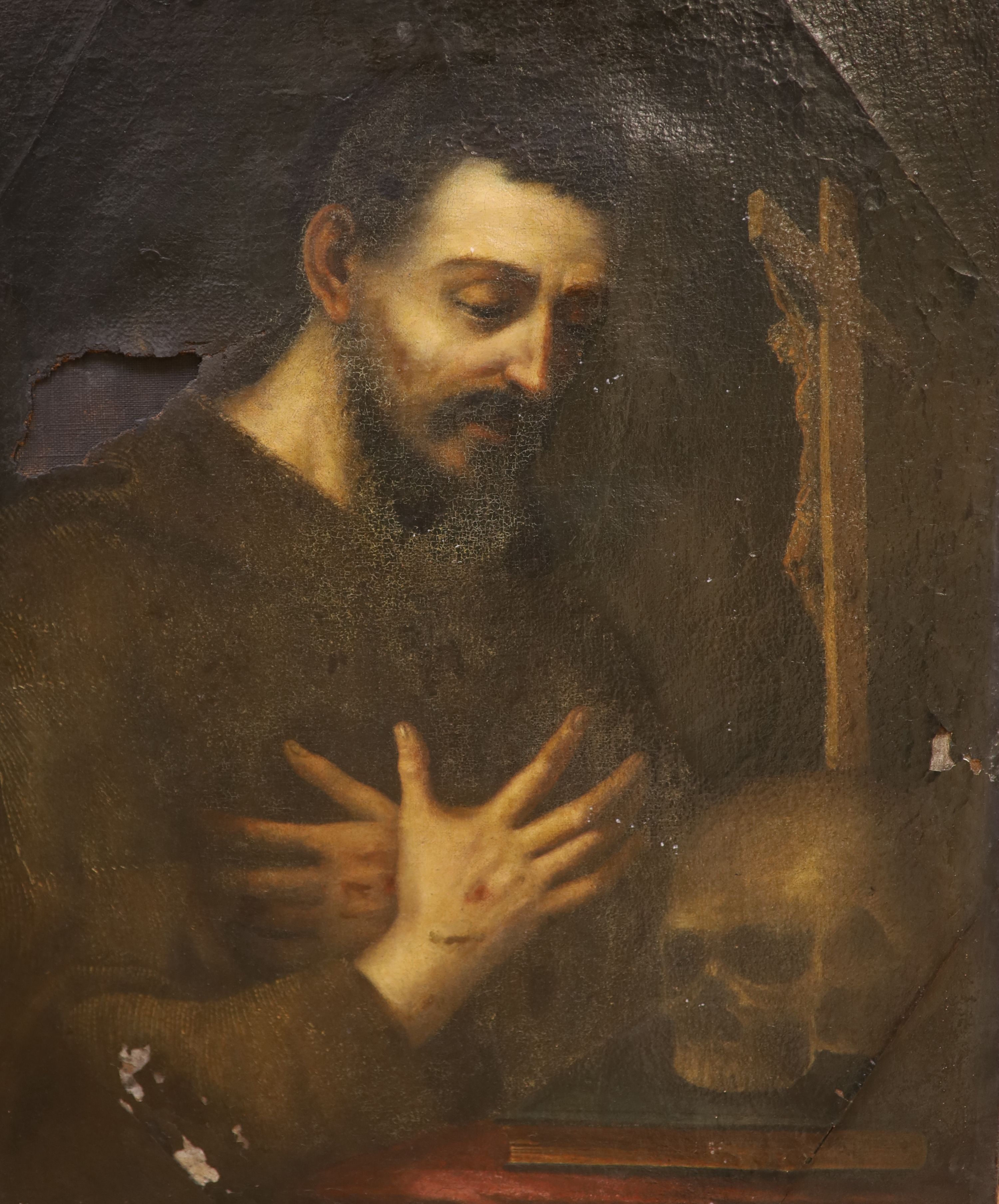 19th Century Continental School, oil on canvas, study of a monk in contemplation, the figure beside a desk with a skull, bible and crucifix, his hands bearing stigmata, (A/F) 74 x 58 cm.